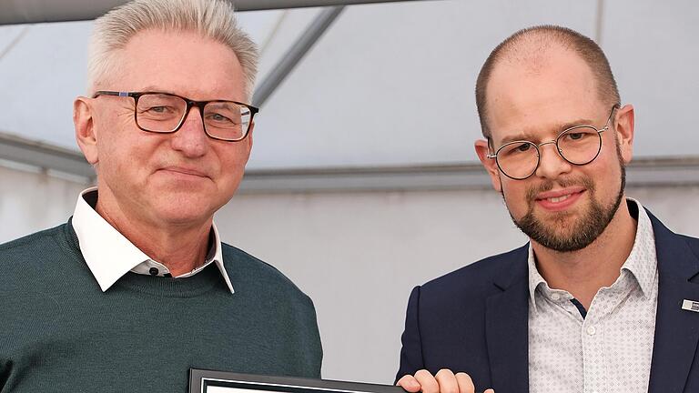 Justiziar Jan-Markus Momberg (rechts) von der IHK Würzburg überreicht die Ehrenurkunde an Geschäftsführer August Schneider.       -  Justiziar Jan-Markus Momberg (rechts) von der IHK Würzburg überreicht die Ehrenurkunde an Geschäftsführer August Schneider.