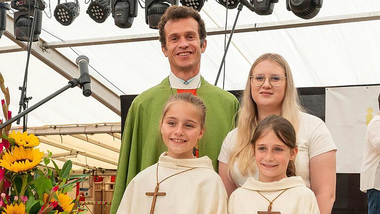 Das Foto zeigt die neuen Minis Lia Büdel und Leonie Sauer (vordere Reihe von links) mit Pfarrer Michael Schmitt und Caroline Friedel.