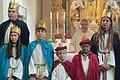 Die Sternsinger in der Kirche. Auf dem Foto von links:  Nico Scheiner, Amy Loder, Bastian Barthel, Korbinian Mayer, Ella Schenk und Eva Scheiner.  Am Altar steht Pfarrer Günter Höfler.