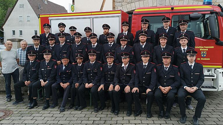 Die Abteilung Wenkheim der Gesamtfeuerwehr Werbach im Jubiläumsjahr mit Abteilungskommandant Marcel Rauch (sitzend Sechster von rechts). Im Hintergrund das neu angeschaffte Einsatzfahrzeug.&nbsp;