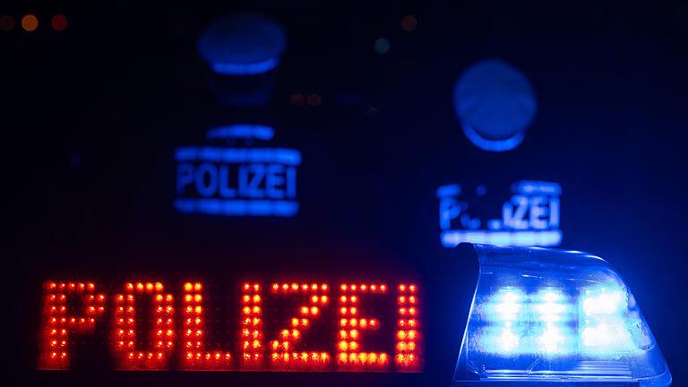 Zwei Polizisten stehen vor einem Streifenwagen - Illustration       -  Symbolbild: Polizei