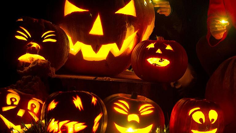 Selbstgeschnitzte Halloween-Kürbisse leuchten in einem Garten. Sie haben auch so ein oranges Kunstwerk geschaffen? Dann lassen Sie das Foto gerne der Redaktion zukommen.